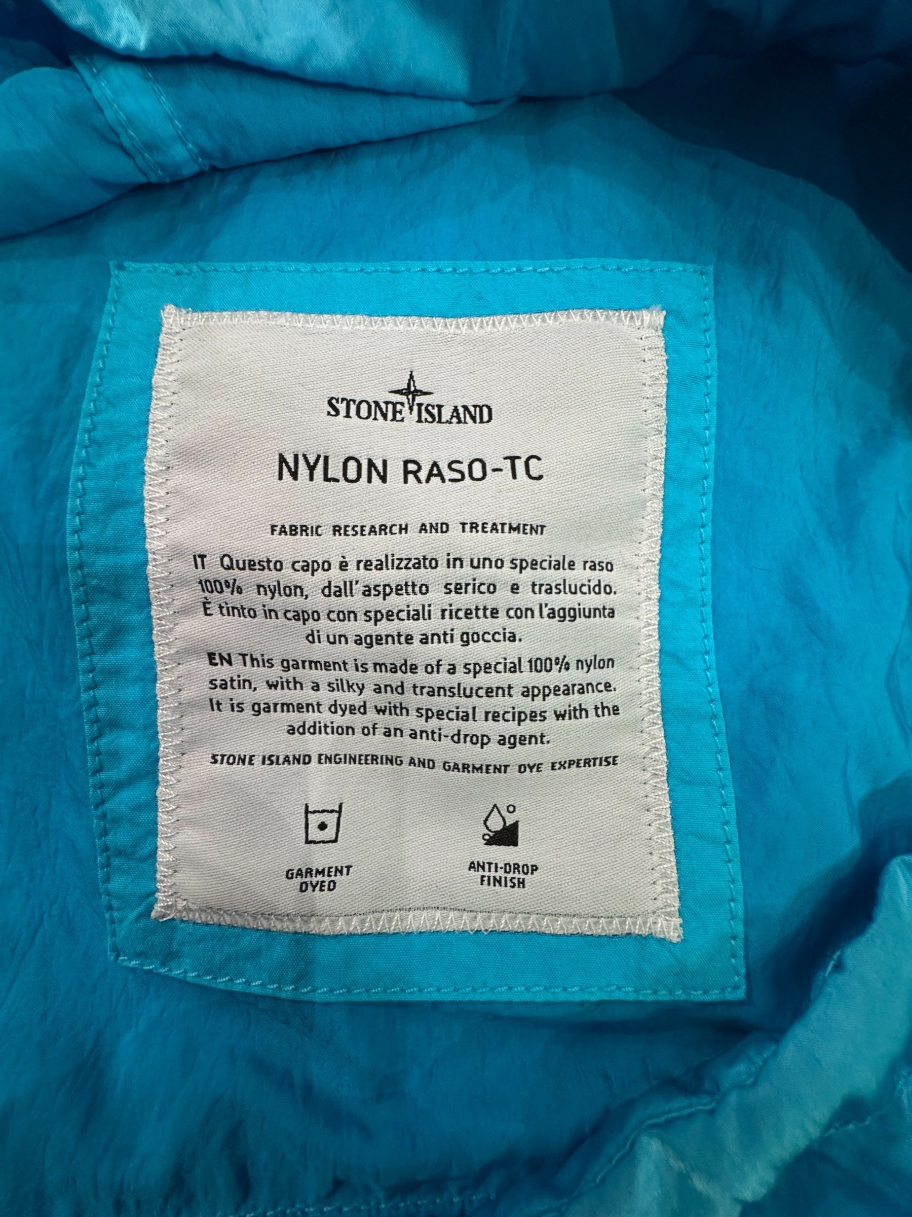 Urban Saints Stone Island Nylon Raso-TC jacket interior label detailing fabric research and garment dye information.